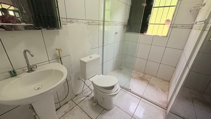 Casa de banho social com louças brancas completas, revestimento cerâmico e resguardo em vidro temperado na zona sul de Porto Velho com a imobiliária em Porto Velho