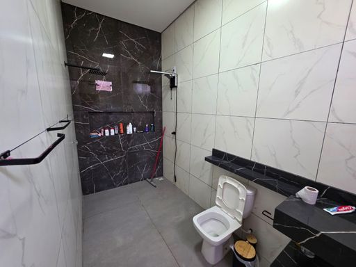 Banheiro moderno de imóvel no bairro Conceição, zona sul de Porto Velho, com revestimento cerâmico, bancada em granito, box e acabamento em tons claros e escuros.