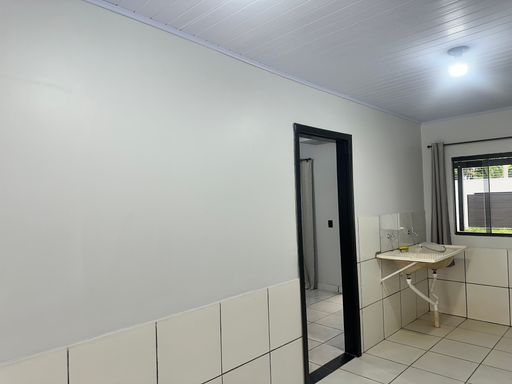 Detalhe da área de serviço/cozinha com revestimento cerâmico protetivo nas áreas molhadas e integração com o corredor lateral no Bairro Nova Esperança, em Porto Velho-RO.