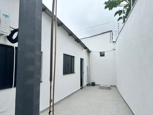 Perspectiva do fundo do lote destacando a infraestrutura de abastecimento hídrico e a robustez do fechamento perimetral no Bairro Nova Esperança, em Porto Velho-RO.