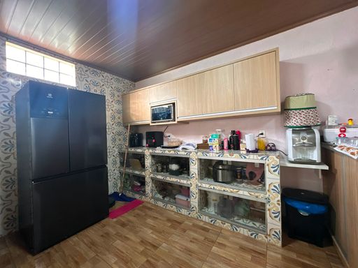 cozinha com balcão feito de cerâmica e eletrodomésticos sobre a bancada.