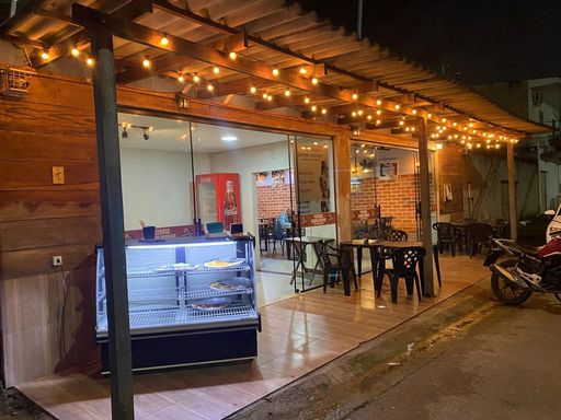Fachada interna com fechamento em grandes panos de vidro temperado e varanda frontal coberta, equipada com balcão expositor refrigerado no Bairro Esperança da Comunidade, em Porto Velho-RO.