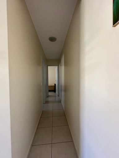 Corredor de circulação interna com iluminação centralizada, conectando de forma privativa a área social aos dormitórios no Bairro Aeroclube, em Porto Velho-RO.