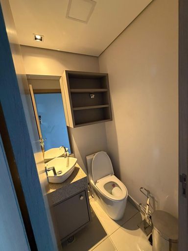 Lavabo moderno no corredor com bancada em granito e acabamento refinado, ideal para visitas em apartamento de alto padrão.