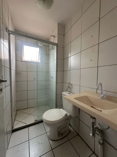 Banheiro social com revestimento cerâmico até o teto, box em vidro, bancada com cuba e louças sanitárias, oferecendo praticidade e fácil manutenção no Bairro Novo, Porto Velho/RO.