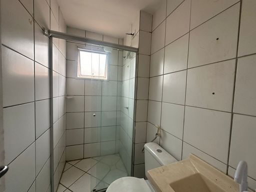 Detalhe da área de banho com box em vidro, revestimento claro e bom aproveitamento do espaço, ideal para apartamento funcional em Porto Velho.