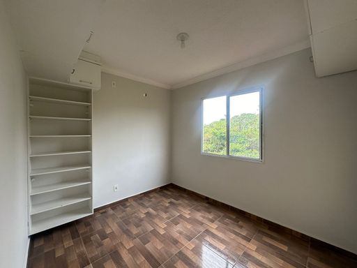 Quarto com armário aéreo e prateleiras integradas, solução prática de armazenamento para apartamento compacto no Bairro Novo, em Porto Velho/RO.