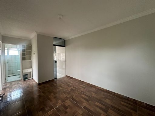 Quarto com piso amadeirado, acesso direto ao banheiro e nicho organizador. Layout prático com boa circulação, oferecendo conforto e funcionalidade para apartamento no Bairro Novo, Porto Velho/RO.