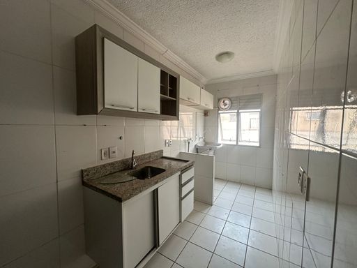 Cozinha planejada em apartamento no Bairro Novo, Porto Velho/RO, com bancada em granito, armários sob medida, pia em inox, piso cerâmico e revestimento nas paredes.