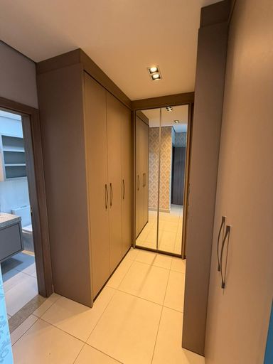 Closet amplo com armários planejados na suíte principal, ideal para organização e praticidade no dia a dia.