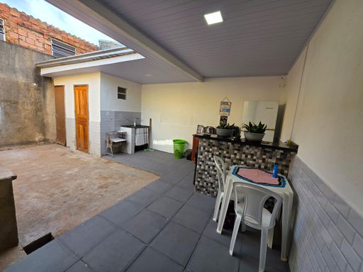 Área externa coberta do imóvel no Condomínio Dália, bairro Novo em Porto Velho, com espaço para mesa e convivência familiar.