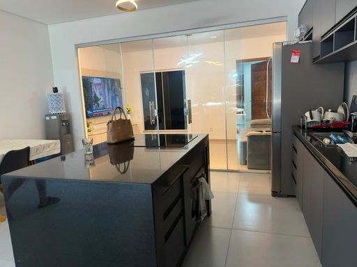 Vista detalhada da área de preparação da cozinha gourmet, destacando a paginação dos armários aéreos e a integração com o acesso social em vidro no Bairro Aponiã, em Porto Velho-RO.