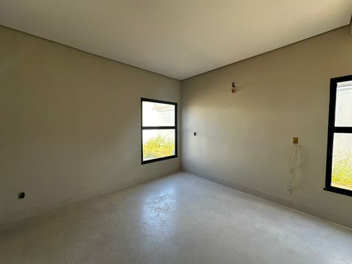 Vista complementar de segundo dormitório/suíte, destacando a janela verticalizada em alumínio preto com vista para o recuo externo e infraestrutura pronta para pontos elétricos na alvenaria no Bairro Triângulo, em Porto Velho-RO.
