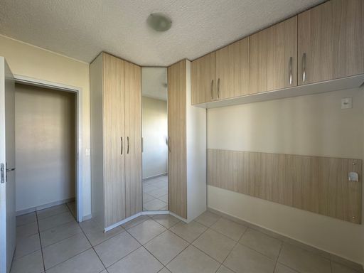Detalhe da marcenaria do quarto master, destacando o espelho de corpo inteiro e o aproveitamento vertical do pé-direito no Bairro Aeroclube, em Porto Velho-RO.