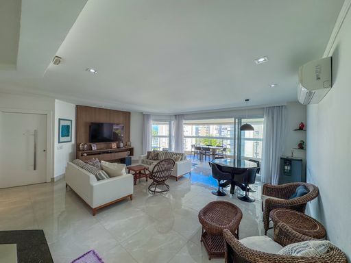 Sala integrada com móveis rústicos
Amplo living de apartamento com sofás claros, poltronas rústicas e piso brilhante.
Esta ampla sala de estar integrada  apresenta sofás em tecido claro dispostos em paralelo a poltronas e mesas de centro feitas de fibra sintética escura, criando um contraste rústico e sofisticado. Ao fundo, um painel de madeira apoia a televisão, enquanto grandes portas de correr de vidro se abrem para a varanda inundada de luz natural. O piso em porcelanato polido claro e o teto de gesso com iluminação embutida dão um toque de modernidade e frescor ao ambiente.
