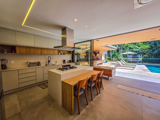 Cozinha americana planejada

Ilha central de cozinha com cooktop e bancada em madeira clara.

Esta cozinha moderna apresenta uma ilha central em tom bege equipada com cooktop, integrada a uma mesa de refeições rápidas em madeira clara. Os armários superiores seguem uma linha minimalista em tons neutros, complementados por iluminação de fita LED sob os nichos. Grandes portas de vidro ao fundo garantem ventilação permanente e acesso direto à área externa gourmet. A combinação de superfícies lisas e madeira natural resulta em uma estética funcional e sofisticada, com sensação de frescor e organização.