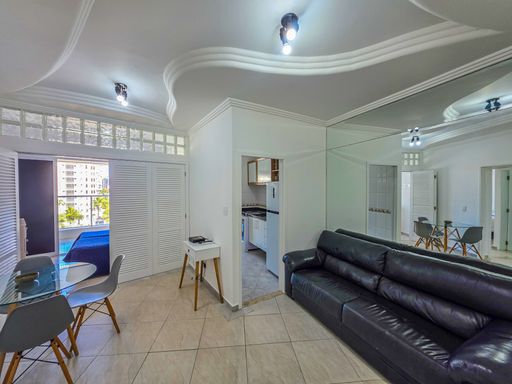 Sala de estar moderna integrada.

Sala de estar com sofá de couro preto e mesa de jantar.

Uma sala de estar contemporânea que utiliza uma paleta de cores neutras e mobiliário minimalista. O destaque é o amplo sofá de couro preto posicionado estrategicamente para otimizar o espaço, complementado por uma mesa de canto branca com pés de madeira. O teto possui um acabamento em gesso trabalhado com sancas, acompanhado de iluminação direta por spots pretos. A integração com a cozinha é sutil, mantendo a estética limpa e organizada, com uma sensação de amplitude e conforto térmico.