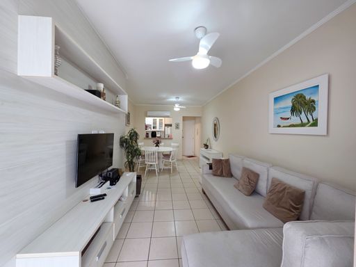 Living com vista do corredor

Visão longitudinal da sala de estar em direção à entrada e cozinha.

Esta imagem revela a profundidade do imóvel, mostrando a sala de estar mobiliada com sofá bege e painel de TV branco em primeiro plano. Ao fundo, observa-se a mesa de jantar e o acesso à cozinha, integrando todos os espaços sociais. O forro de gesso com sancas e spots garante uma iluminação uniforme, enquanto os ventiladores de teto asseguram o bem-estar térmico. A estética é contemporânea e organizada, utilizando cores claras para ampliar visualmente os ambientes.