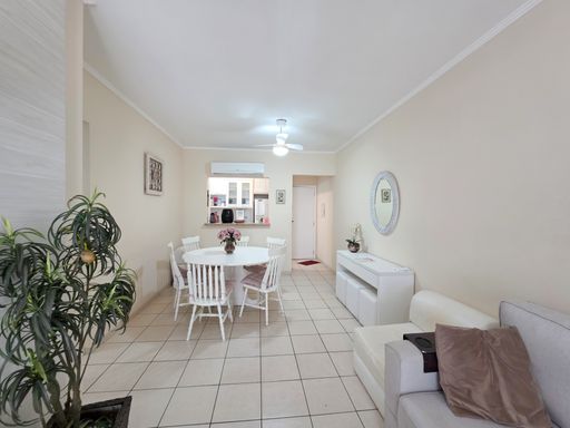 Living e mesa de jantar

Visão geral da sala integrando áreas de estar e jantar sob luz suave.

O living exibe um layout harmonioso, conectando o sofá confortável com almofadas marrons à mesa de jantar circular. Quadros com paisagens tropicais e plantas em vasos escuros trazem elementos da natureza para dentro de casa. A iluminação centralizada nos ventiladores de teto proporciona claridade e ventilação simultâneas. A estética é residencial e acolhedora, utilizando tons de bege e branco para criar uma atmosfera de serenidade e conforto térmico constante.Sala de jantar decorada

Mesa de jantar branca com arranjo de flores e balcão de cozinha ao fundo.