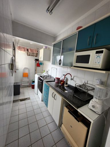 Cozinha linear montada

Cozinha americana estreita com armários planejados, pia de granito e eletrodomésticos.

Cozinha em estilo corredor com revestimento cerâmico branco nas paredes e piso claro. A bancada principal é feita de granito escuro, equipada com uma cuba de inox, torneira vermelha flexível e escorredor de louças. Armários planejados combinam portas brancas e gavetas com detalhes em azul-petróleo na parte superior. Sobre a bancada, um forno de micro-ondas está posicionado em um nicho próprio. Ao fundo, avista-se a área de serviço integrada. O ambiente transmite praticidade, aproveitamento de espaço e uma estética funcional.Banheiro com box de vidro

Banheiro moderno com box de vidro verde, vaso sanitário e bancada de granito.

Banheiro social funcional com área do box delimitada por portas de vidro temperado em tom esverdeado e esquadrias pretas. A bancada é esculpida em granito ornamental salpicado, trazendo uma textura natural ao espaço, e conta com uma cuba de apoio branca e torneira metálica cromada. Acima da bancada, um espelho retangular amplo amplia visualmente o ambiente. O vaso sanitário branco está posicionado na lateral esquerda. O revestimento cerâmico e a iluminação embutida reforçam a sensação de asseio e modernidade.
