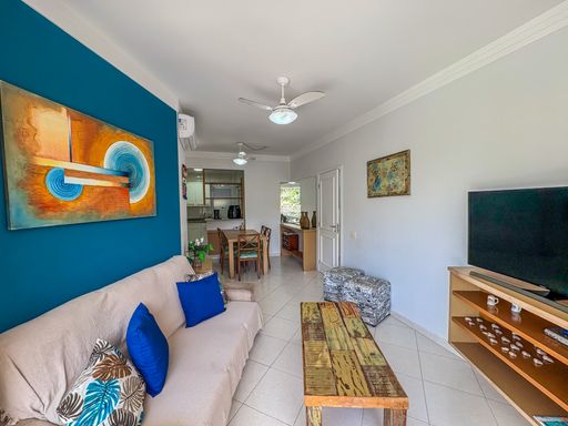 Espaço social integrado com jantar

Visão da sala de estar conectada à área de jantar ao fundo.

Esta imagem revela a integração entre o living e a sala de jantar, ampliando a percepção de espaço. O sofá com almofadas azuis e a mesa rústica permanecem como protagonistas no primeiro plano, enquanto ao fundo observa-se a mesa de jantar em madeira com cadeiras coordenadas. O piso cerâmico uniforme percorre todo o imóvel, reforçando a continuidade visual. A iluminação é composta por múltiplos ventiladores de teto, garantindo circulação de ar constante. A decoração equilibrada entre o moderno e o rústico cria uma estética funcional para convívio social.