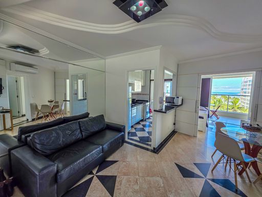 Sala de estar moderna integrada.

Interior de sala com sofá de couro preto e mesa de jantar.

Uma sala de estar contemporânea caracterizada por um sofá de couro preto de design minimalista e teto de gesso trabalhado com sancas iluminadas. O piso de porcelanato polido apresenta detalhes geométricos em tons escuros que adicionam sofisticação ao ambiente. Espelhos instalados em paredes estratégicas ampliam a percepção de espaço e refletem a luz natural vinda da varanda integrada. A estética é limpa e luxuosa, oferecendo uma sensação térmica agradável graças ao sistema de ar-condicionado e à integração fluida entre os cômodos.