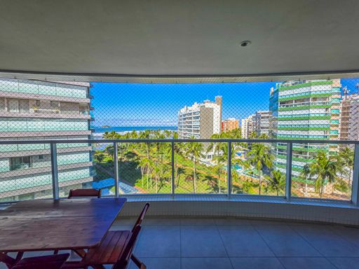 Vista panorâmica da sacada.

Oceano e coqueiros vistos através de guarda-corpo de vidro.

A fotografia foca na localização estratégica do imóvel, oferecendo uma visão frontal da praia e da linha do horizonte. Entre os edifícios modernos, destaca-se a densa vegetação tropical e a areia clara da costa. A mesa de madeira no canto inferior esquerdo sugere um ambiente de contemplação. A abundância de luz solar realça as cores vibrantes do mar e da natureza, transmitindo uma estética de exclusividade e tranquilidade. A sensação térmica é de frescor, potencializada pela brisa marinha que circula livremente pela abertura.