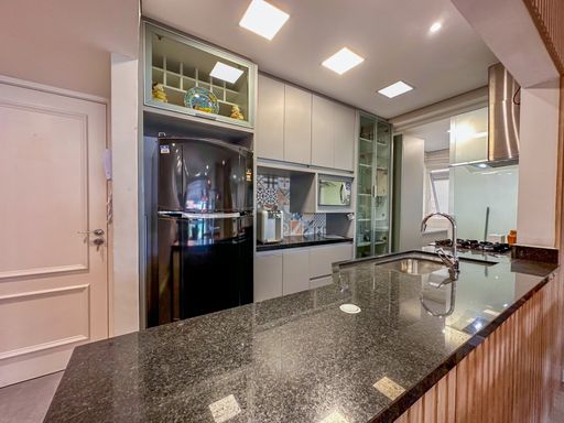 Cozinha planejada com balcão de granito

Cozinha americana com bancada de granito preto absoluto e geladeira de inox.

Uma cozinha planejada de alto padrão que esbanja modernidade e eficiência funcional. Apresenta móveis sob medida com portas em laca cinza clara ou vidro fosco e nichos superiores decorativos. A bancada americana em granito preto absoluto acomoda a cuba de inox embutida e delimita o espaço com a sala. Equipamentos modernos em aço inoxidável, incluindo uma grande geladeira duplex e coifa embutida, completam o espaço. A iluminação por painéis de LED garante excelente visibilidade, transmitindo limpeza, sofisticação e praticidade culinária.
