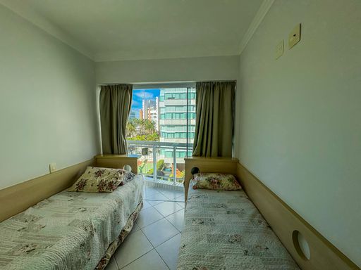 Quarto de solteiro duplo arejado

Dormitório com duas camas de solteiro paralelas e enxoval em tons pastéis.

Este quarto de solteiro é configurado para acomodar duas pessoas com camas individuais dispostas paralelamente. As camas possuem painéis de cabeceira em madeira clara integrados à parede. O piso cerâmico e as paredes brancas reforçam a luminosidade que entra pela janela de correr. As cortinas em tom neutro garantem a privacidade necessária. O ambiente é simples, funcional e transmite uma sensação de frescor e ordem, ideal para hóspedes ou crianças.