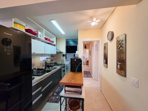 Cozinha planejada estilo corredor

Cozinha planejada com armários escuros, bancada de granito e balcão de madeira.

Uma cozinha planejada em estilo corredor que otimiza perfeitamente o espaço residencial. O ambiente conta com armários inferiores em tom cinza-escuro texturizado e armários aéreos brancos com nichos superiores decorados com louças vermelhas. A bancada longa em granito claro abriga uma pia de inox com torneira gourmet preta e um fogão embutido. Um balcão de apoio em madeira maciça com banquetas cria uma charmosa divisória com o corredor. A iluminação é direta e funcional, complementada pelas paredes de tom creme que trazem sensação de amplitude e aconchego.