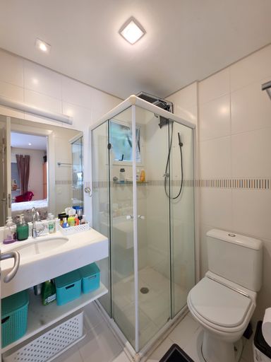 Banheiro social limpo e funcional

Banheiro com box de vidro blindex, pia suspensa e bacia sanitária.

Um banheiro compacto projetado com foco na praticidade e organização. As paredes são inteiramente revestidas por azulejos cerâmicos brancos com um detalhe em faixa horizontal pastilhada. O box de canto possui esquadrias brancas e vidros transparentes, otimizando o espaço da área de banho. Uma bancada suspensa de louça branca abriga a pia e organiza produtos de higiene diária, acompanhada por um espelho retangular iluminado. Caixas organizadoras azuis sob a bancada adicionam uma cor vibrante ao décor neutro.