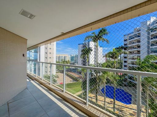 Sacada integrada com rede de proteção
Sacada de apartamento com piso frio, guarda-corpo de vidro e rede de proteção.
Esta sacada retilínea apresenta um piso cerâmico cinza e guarda-corpo de alumínio branco com fechamento em vidro, equipado com rede de proteção para segurança. A iluminação natural é abundante, destacando a parede lateral revestida em cerâmica bege. A vista externa revela palmeiras, a área de lazer do condomínio com uma piscina azul e edifícios residenciais ao fundo, conferindo uma atmosfera urbana e litorânea ao mesmo tempo.