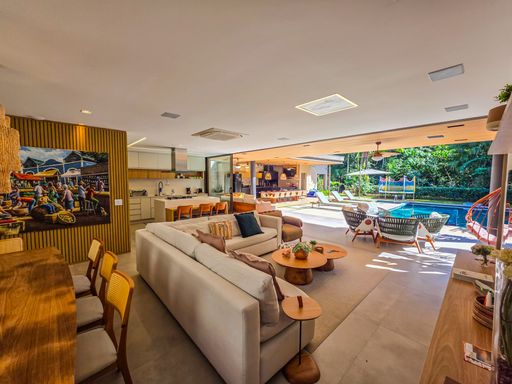 Cozinha e living integrados

Visão da sala de estar conectada à cozinha americana moderna.

O espaço integra harmoniosamente o living com uma cozinha de conceito aberto. O sofá claro e a mesa de centro em madeira compõem a área de descanso, enquanto ao fundo observa-se uma cozinha equipada com armários planejados e bancada funcional. O piso cerâmico uniforme amplia visualmente o ambiente, que é iluminado por luz natural e spots embutidos no forro de gesso. A paleta de cores neutras e o uso de materiais naturais conferem uma estética limpa, moderna e termicamente confortável.
