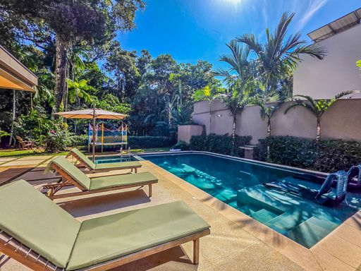 Lounge externo sombreado

Deck de lazer com espreguiçadeiras confortáveis frente à piscina e jardim.

O lounge externo é mobiliado com espreguiçadeiras de alumínio e tecido verde, posicionadas estrategicamente para o descanso pós-banho de piscina. O paisagismo denso ao redor oferece sombra natural e privacidade total aos moradores. A piscina de bordas retas estende-se lateralmente, refletindo a luz solar intensa do dia. A estética é de um oásis de tranquilidade, onde a sensação térmica é de calor ameno graças à proximidade com a água e a vegetação.