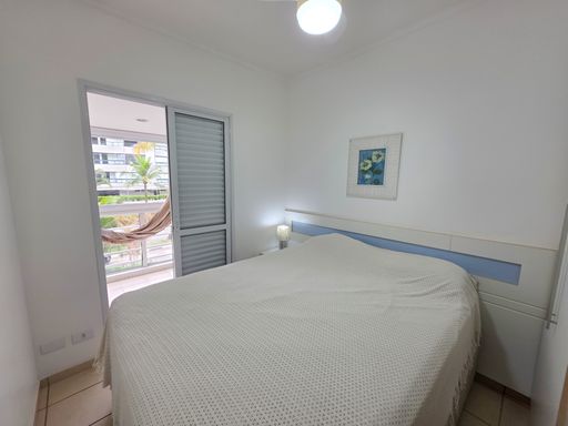 Dormitório de casal com varanda

Quarto amplo com cama queen, acesso à sacada e iluminação suave.

Este quarto principal destaca-se pelo acesso direto à varanda através de portas de correr de vidro, proporcionando luz natural e ventilação permanente. A cama queen size com enxoval branco ocupa o centro do ambiente, que conta com detalhes em azul na marcenaria. Um quadro artístico na parede traz personalidade ao espaço, enquanto o ventilador de teto garante o conforto térmico. A estética é de um refúgio privativo arejado e sofisticado, com uma sensação térmica de frescor litorâneo e tranquilidade.