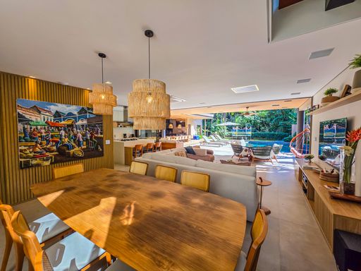 Integração entre salas e lazer

Visão ampla do living e jantar conectada à piscina externa.  

Esta perspectiva destaca a integração máxima entre as salas de estar e jantar com o terraço externo. O mobiliário utiliza materiais naturais como madeira e palha, harmonizando com o piso de porcelanato neutro de grande formato. Grandes telas de arte contemporânea adornam as paredes, enquanto a iluminação estratégica valoriza cada detalhe decorativo. O ambiente transmite uma estética de luxo descontraído, ideal para recepções, com uma sensação térmica constante de ventilação cruzada.