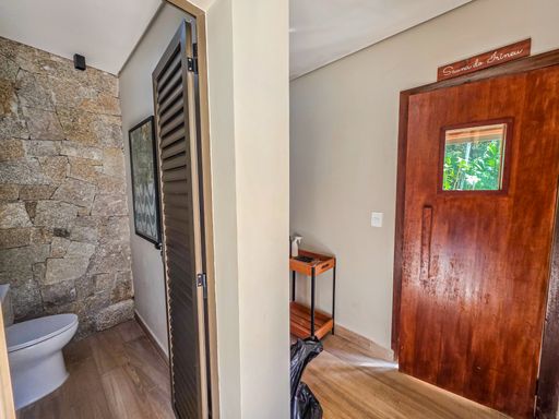 Entrada de sauna e vestiário

Visão de corredor interno com parede de pedra bruta e porta de madeira.

O acesso à área de bem-estar é marcado por uma parede revestida em pedra natural bruta e piso em tom amadeirado. Uma porta de madeira maciça com visor de vidro indica a entrada para um espaço reservado, possivelmente uma sauna ou vestiário. O ambiente conta com uma iluminação suave e zenital, realçando as texturas minerais e orgânicas. A estética remete a um spa de luxo, com uma sensação térmica de acolhimento e isolamento acústico.