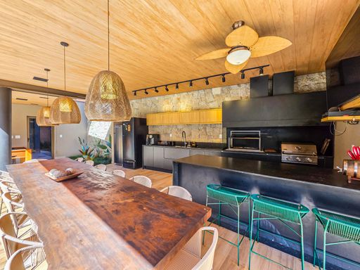 Cozinha gourmet e bar de drinks

Bancada de bar preta equipada com chopeira, pendentes de palha e banquetas verdes.

Este espaço gourmet vibrante apresenta uma longa bancada de granito preto equipada com uma chopeira de duas vias e metais modernos. Banquetas de metal em tom verde esmeralda trazem cor ao ambiente, complementado por pendentes artesanais de fibra natural. Ao fundo, a churrasqueira e os armários planejados garantem funcionalidade completa. A estética é de um "beach club" privativo e sofisticado, com sensação térmica refrescante sob o amplo teto de madeira com ventiladores.