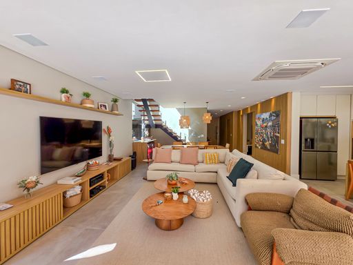 Living integrado e escada

Sala de estar com sofá em L, rack de madeira e escada flutuante ao fundo.

O living interno é mobiliado de forma minimalista, com um sofá modular bege e um longo rack de madeira que percorre a parede lateral. Ao fundo, a escada flutuante e a mesa de jantar com pendentes rústicos adicionam camadas de textura e design ao projeto. O sistema de climatização embutido garante o conforto em dias de calor excessivo. A estética é serena e sofisticada, utilizando tons neutros para criar uma atmosfera de acolhimento e modernidade.