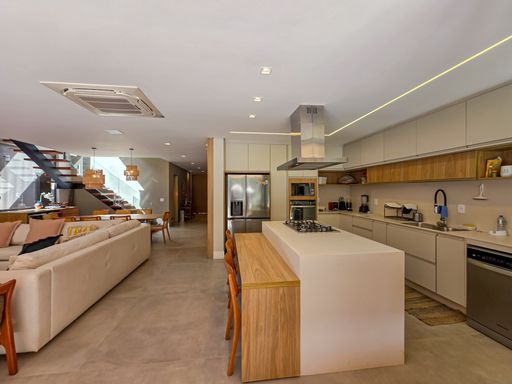Cozinha planejada minimalista

Cozinha americana com ilha branca, armários embutidos e eletrodomésticos inox.

Esta cozinha de design clean apresenta armários planejados em tons neutros e uma ilha central em material branco sólido que serve como bancada de preparo. O teto possui sanca de LED e spots embutidos, garantindo iluminação funcional e cênica. Integrada ao living, a cozinha utiliza marcenaria em madeira clara para aquecer o visual predominantemente branco. A sensação térmica é de limpeza e frescor, com uma estética funcional de altíssimo padrão para o uso cotidiano.