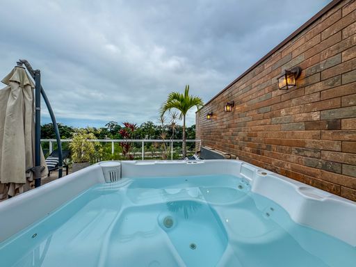 Jacuzzi de cobertura com vista.

Jacuzzi de madeira ao ar livre com vista para a natureza.

Esta imagem retrata a área de lazer externa em uma cobertura de luxo em um dia nublado. No centro, uma jacuzzi de madeira está cercada por um deck de madeira e azulejos claros. Vasos de plantas tropicais e iluminação embutida nas paredes de tijolos de argila flanqueiam a área da jacuzzi. O ambiente é cercado por um parapeito de vidro e alumínio, oferecendo uma vista panorâmica para uma área verde exuberante. O ambiente é fresco e tranquilo, com uma estética rústica e industrial que promove o lazer e bem-estar.