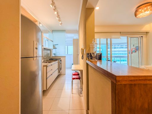 Cozinha americana com balcão

Cozinha americana com balcão de madeira comprido e geladeira de inox.

Cozinha americana planejada com design retilíneo e otimização de espaço. Apresenta um balcão de madeira maciça de tom quente que divide os ambientes e serve de apoio. Os armários planejados inferiores possuem acabamento em marcenaria clara e puxadores em perfil de alumínio embutido. A bancada é em granito cinza e comporta cooktop e pia embutida. Eletrodomésticos em aço inoxidável escovado, como a geladeira duplex, trazem modernidade. A iluminação de trilho com spots direcionáveis no teto destaca o corredor de circulação e o piso frio claro, criando uma atmosfera funcional, limpa e bem iluminada.