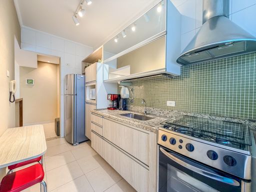 Cozinha planejada com revestimento verde

Cozinha linear com revestimento de pastilhas verdes e armários aéreos espelhados.

Cozinha compacta de layout linear decorada com parede revestida em pastilhas de vidro verdes e cinzas, conferindo personalidade e vivacidade ao espaço. A bancada em granito cinza ornamental abriga uma cuba de inox com torneira alta e um fogão de piso em aço inox com coifa de parede instalada logo acima. Os armários aéreos possuem portas de vidro reflecta e iluminação embutida, enquanto os gabinetes inferiores seguem uma paleta de madeira clara com veios horizontais. A iluminação em spots e o piso de cerâmica clara complementam a estética moderna, limpa e funcional do ambiente gourmet.