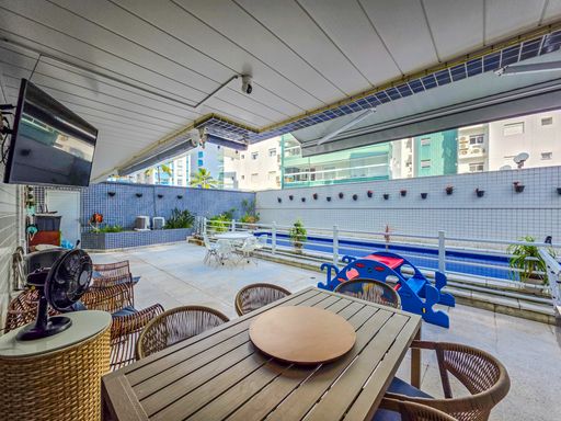 Área gourmet externa com piscina

Mesa de madeira sob toldo com vista para piscina e prédios.

Vista em perspectiva a partir da mesa de refeições externa, destacando a estrutura do toldo retrátil cinza estendido sobre o ambiente. A mesa de madeira ripada e as cadeiras de vime com tecido azul ocupam o primeiro plano. O piso de pedra antiderrapante estende-se até a área da piscina, que é cercada por uma grade de segurança de alumínio. A iluminação natural é abundante, ressaltando o acabamento pastilhado cinza das paredes externas e a arquitetura contemporânea dos edifícios ao redor.