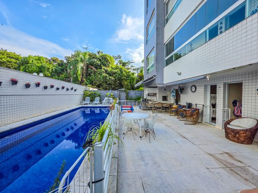 Área externa com piscina privativa

Piscina longa de azulejos azuis em terraço integrado à varanda gourmet.

Uma ampla área externa de lazer na cobertura, destacando uma piscina retangular com revestimento em azulejos azuis e cercada por uma grade de proteção branca. O piso de pedra clara antiderrapante acomoda mesas externas com cadeiras e espreguiçadeiras ao fundo. A lateral do edifício apresenta fachadas modernas com grandes janelas de vidro e detalhes pastilhados, enquanto o muro oposto exibe pequenos vasos de plantas decorativos. A iluminação natural é abundante sob o céu azul com nuvens, criando uma estética ensolarada, refrescante e convidativa.