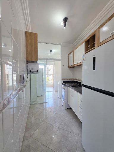 Cozinha funcional com bancada granito.

Cozinha planejada branca com geladeira inox e bancada escura.

Esta cozinha otimizada apresenta armários planejados brancos com detalhes em madeira clara, oferecendo bastante espaço de armazenamento. A bancada em granito escuro contrasta com os revestimentos cerâmicos brancos das paredes, que possuem um detalhe em faixa decorativa. Equipada com eletrodomésticos modernos, incluindo uma geladeira Frost Free branca, o espaço é iluminado por luz branca direta. A funcionalidade é o foco principal, transmitindo uma estética de limpeza, organização e eficiência culinária.