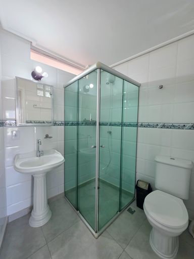 Banheiro social com box vidro.

Banheiro limpo com box de vidro verde e pia branca.

Um banheiro social impecável, revestido com azulejos brancos e uma faixa decorativa em tons de azul e verde. O box de vidro temperado esverdeado adiciona um toque de cor ao espaço neutro. A louça sanitária e a cuba da pia são brancas, com metais cromados de design clássico. O espelho acima da pia amplia o ambiente, que conta com iluminação branca fria. A estética é de higiene e praticidade, com superfícies de cerâmica e vidro que são fáceis de manter, oferecendo uma sensação de frescor.