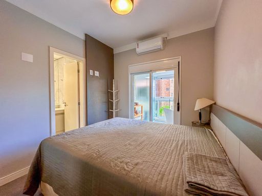 Suíte de casal moderna com varanda

Cama de casal com colcha cinza, cabeceira de madeira e janela para sacada.

Uma sofisticada suíte master planejada para oferecer máximo conforto e tranquilidade ao casal. A cama queen size destaca-se com enxoval em tons de cinza e colcha texturizada, posicionada contra um painel de cabeceira em madeira clara com frisos horizontais. À frente da cama, um painel planejado sob medida acomoda a televisão, otimizando o espaço de passagem. A grande porta de correr de alumínio branco com cortinas fluidas dá acesso direto à varanda privativa, proporcionando excelente ventilação natural, controle de luminosidade e conforto térmico ideal.