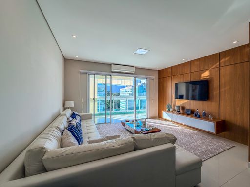 Living com vista externa

Sala de estar com sofá claro e painel de madeira para TV.

Esta sala de estar destaca-se pela integração com a área externa através de amplas portas de vidro. O sofá de tecido claro está posicionado estrategicamente frente ao painel de madeira que ocupa toda a parede, conferindo um toque orgânico ao design contemporâneo. O tapete com grafismos cinzas cobre o piso, proporcionando conforto acústico e térmico. A estética é leve e ensolarada, ideal para um estilo de vida prático e sofisticado.