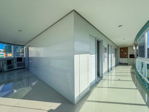 Corredor externo e varanda

Perspectiva lateral de varanda integrada com revestimento branco.

Este ângulo revela a extensão da varanda, conectando diferentes áreas do apartamento. As paredes são revestidas com azulejos brancos pequenos, contrastando com o brilho do piso cerâmico. A iluminação embutida no teto complementa a claridade natural proveniente das grandes lâminas de vidro. O ambiente mantém uma estética minimalista e organizada, sugerindo um fluxo de circulação contínuo e agradável entre os ambientes internos e externos.